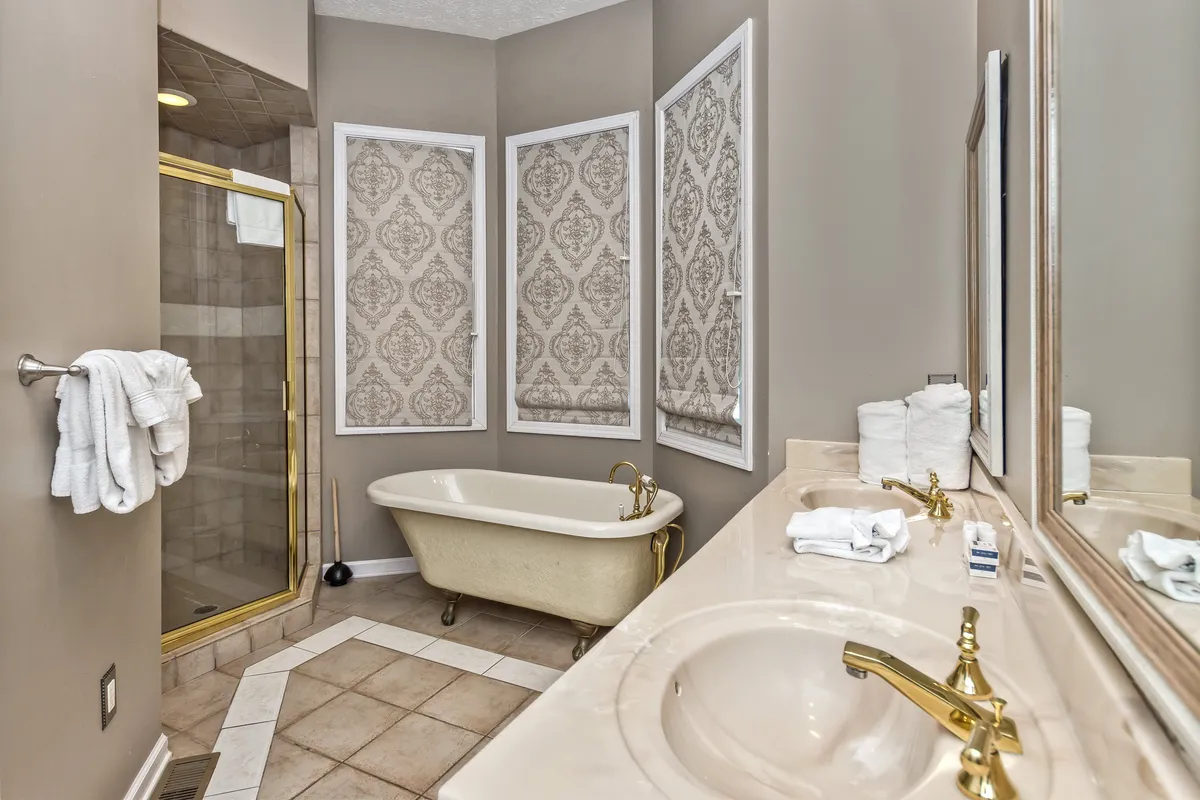 A luxurious en-suite bathroom featuring a freestanding bathtub, separate shower area, and a double vanity. The space is bright and spacious, ideal for unwinding with a relaxing bath or refreshing shower.